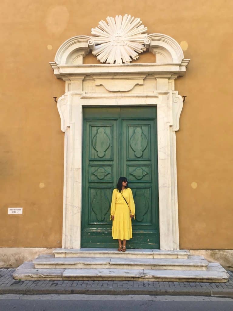 One day in Pisa: Green photogenic large door with bejal standing in front