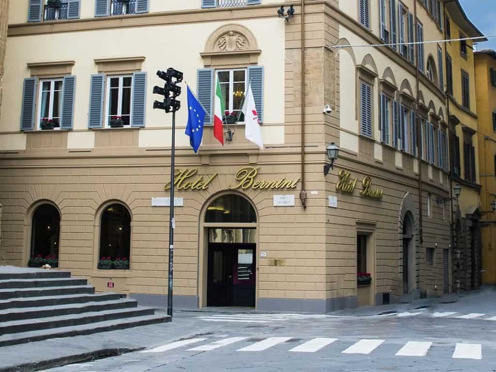 An opulent stay at The Bernini Palace Hotel, Florence The exterior of The Bernini Palace Hotel on a square right in the cnetre of Florence. There are Italian flags outside the light beige and white stone building. There is also a zebra crossing outside the hotel front door, in Florence.