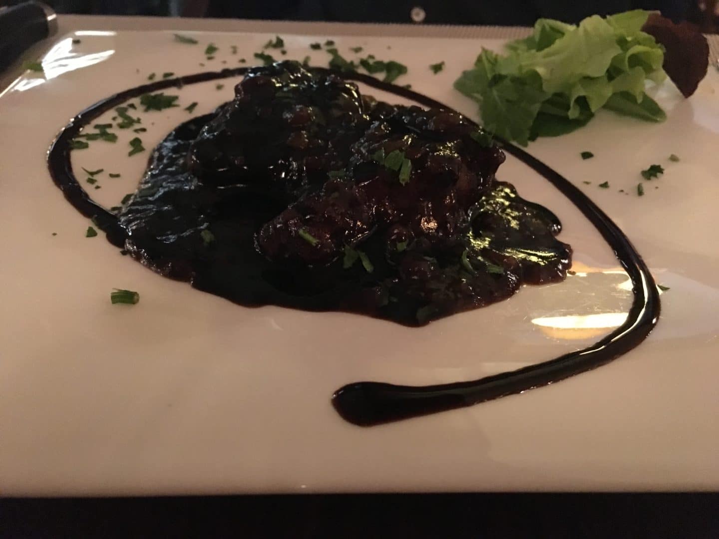 Fine Dining Restaurants in Florence - a white square plate with some lamb in the middle, topped with a balsamic reduction and salad at il Barretto.