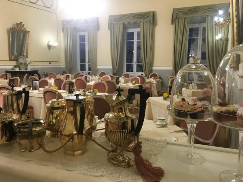 An opulent stay at The Bernini Palace Hotel, Florence An opulent stay at The Bernini Palace Hotel, Florence. The breakfast room with glass domes covering up cakes and pastries. Rows of white linen tables and terracota chairs with 3 long French windows in the background which are framed with olive green drapes.