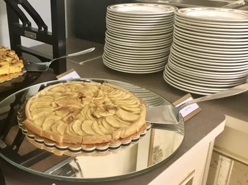 An opulent stay at The Bernini Palace Hotel, Florence Apple tart in its tray laid out for breakfast next to a stack of plates in the hotel's resraurant