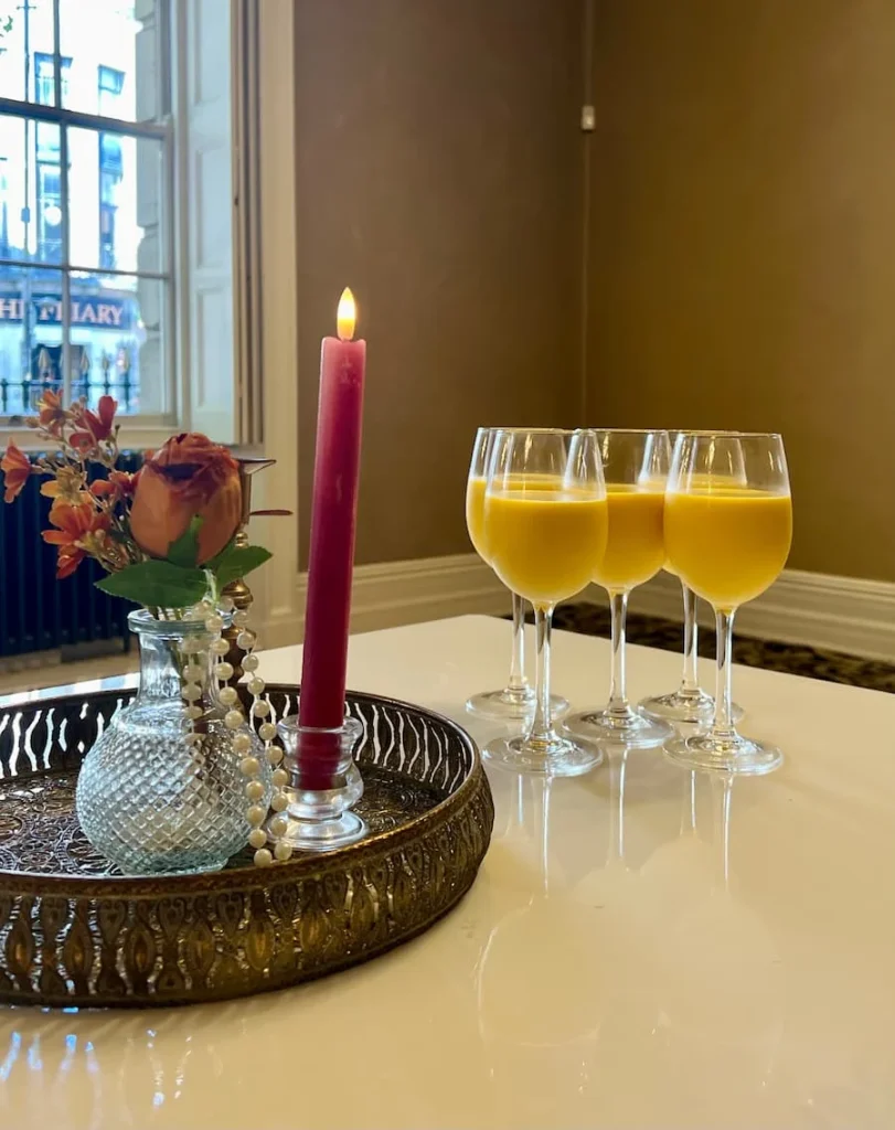 Mango lassis in wine glasses with floral deco at The Indian Afternoon Tea at The City Rooms, Leicester