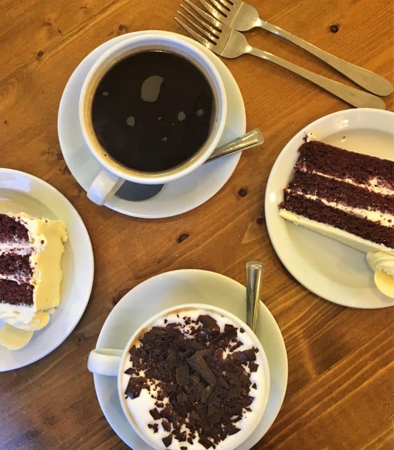 Black coffee, cappuccino with real chocolate sprinkles and black velvet cake at .St Martins Coffee Roasters in Leicester