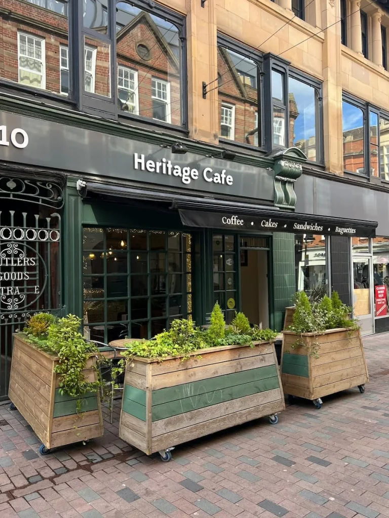 Heritage Cafe exterior with plant boxes and seating and a gate door beside the entrance