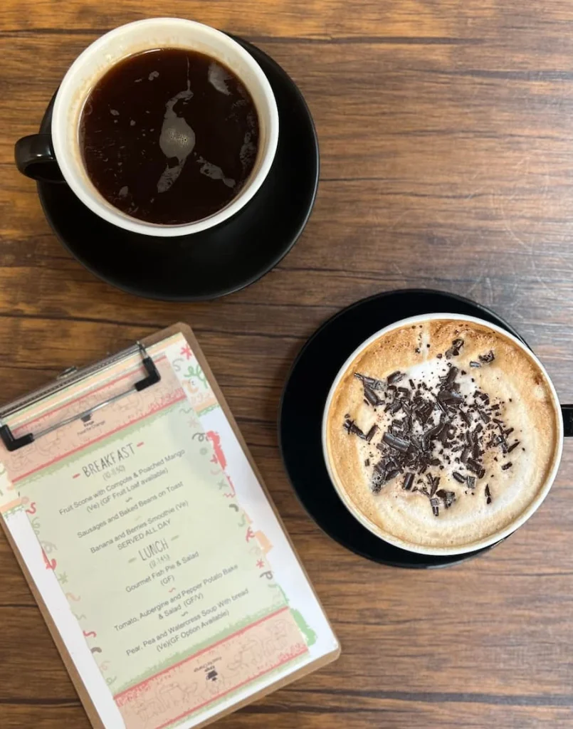 Flat lay of Americano and cappuccino with food waste menu at Kings Coffee House, Leicester
