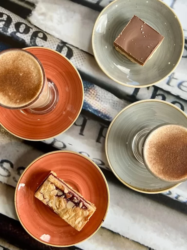 Madisons Coffee Shop, leicester: flat lay of spiced lattes, Bakewell tart and caramel slice