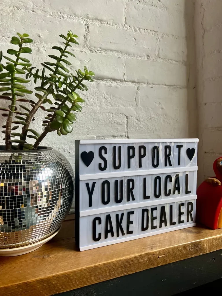 'Support your local cake dealer' sign at Bitsys Emporium, Leicester