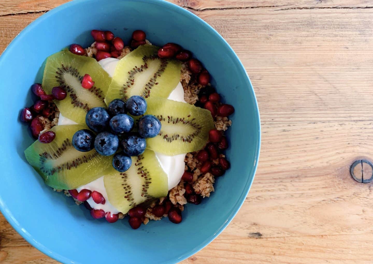 Independent Coffee Shops in LE1, Leicester, A blue bowl of fruit and porridge on a wooden table at Orso Cafe.