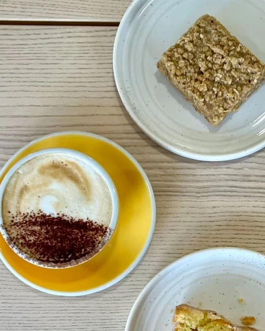 Cappuccino and flapjack flatlay at Way cafe, One Church, Leicester