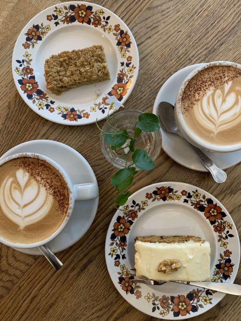 Leicester Coffee House Company cafe. A flat lay of 2 lattes and a flapjack slice and a finger slice of carrot cake.