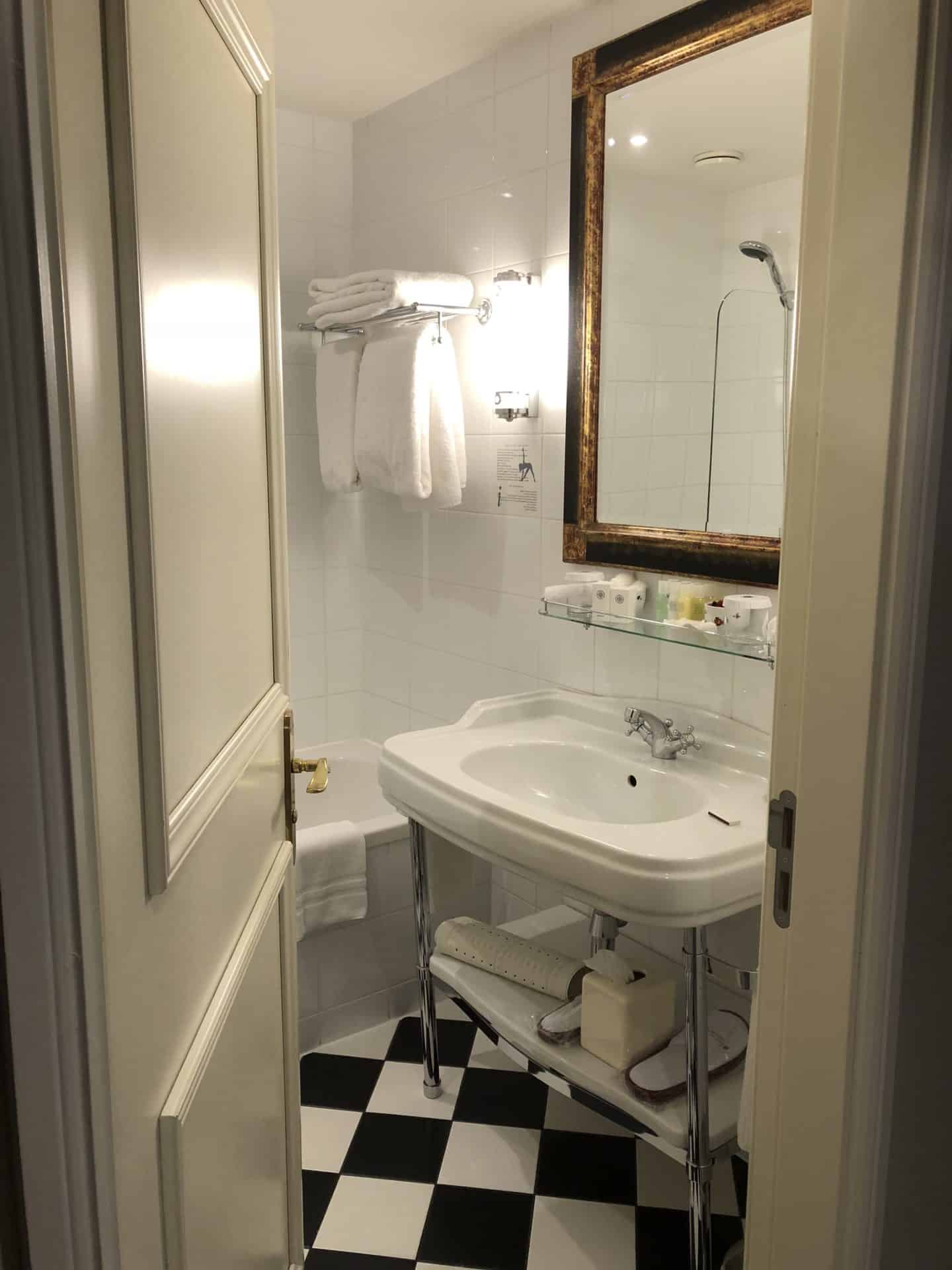 The Grand Palace Hotel Riga deluxe room bathroom with hand basin and bath showing through