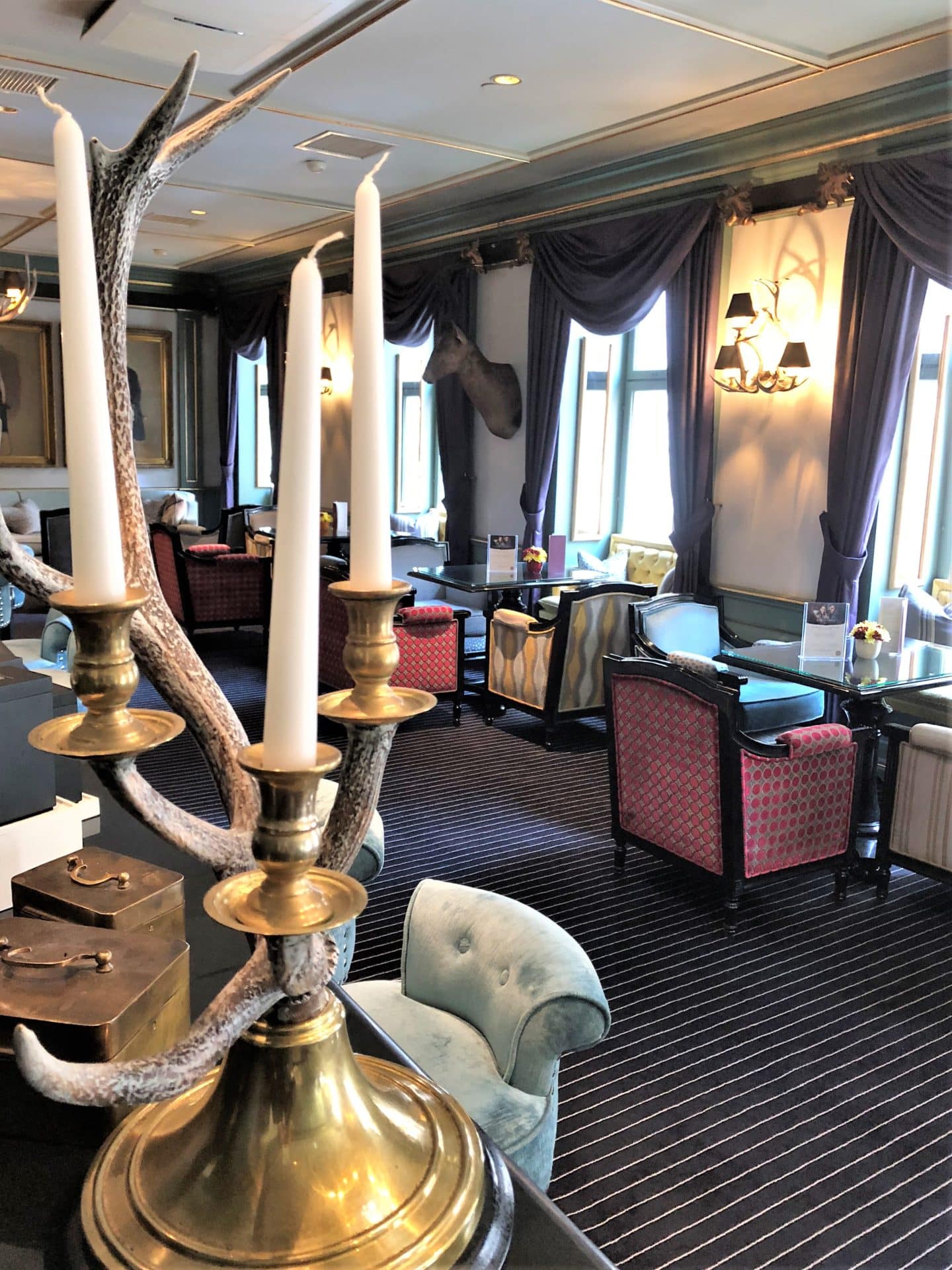 The Grand Palace Hotel Riga, Pils bar with white candles and pink and red seats 