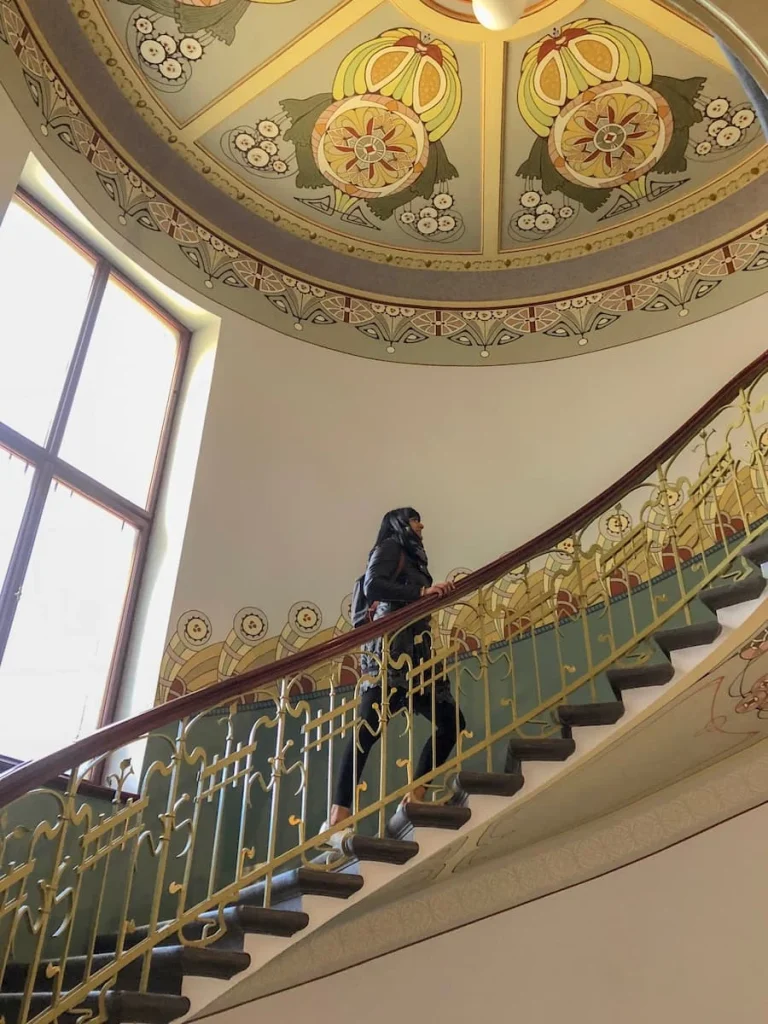 Bejal walking up the Art Nouveau staircase at the Art Nouveau Centre Museum 