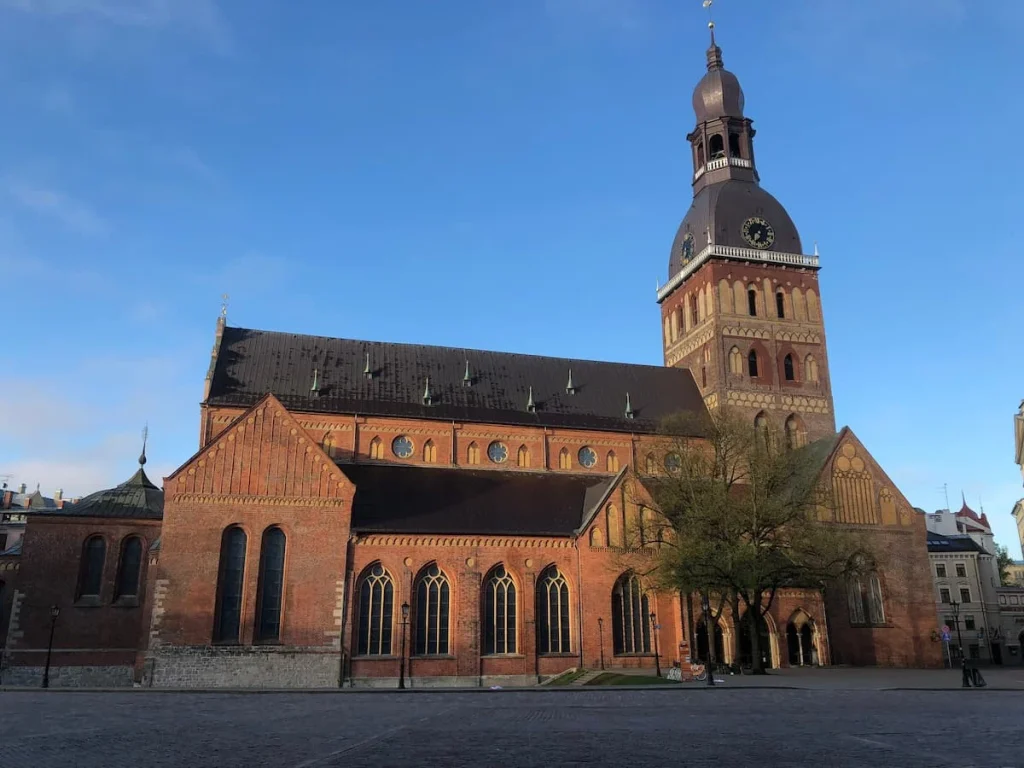 Exterior of Riga Cathedral  in the early morning with a blue sky accentuating the red brick work of teh building