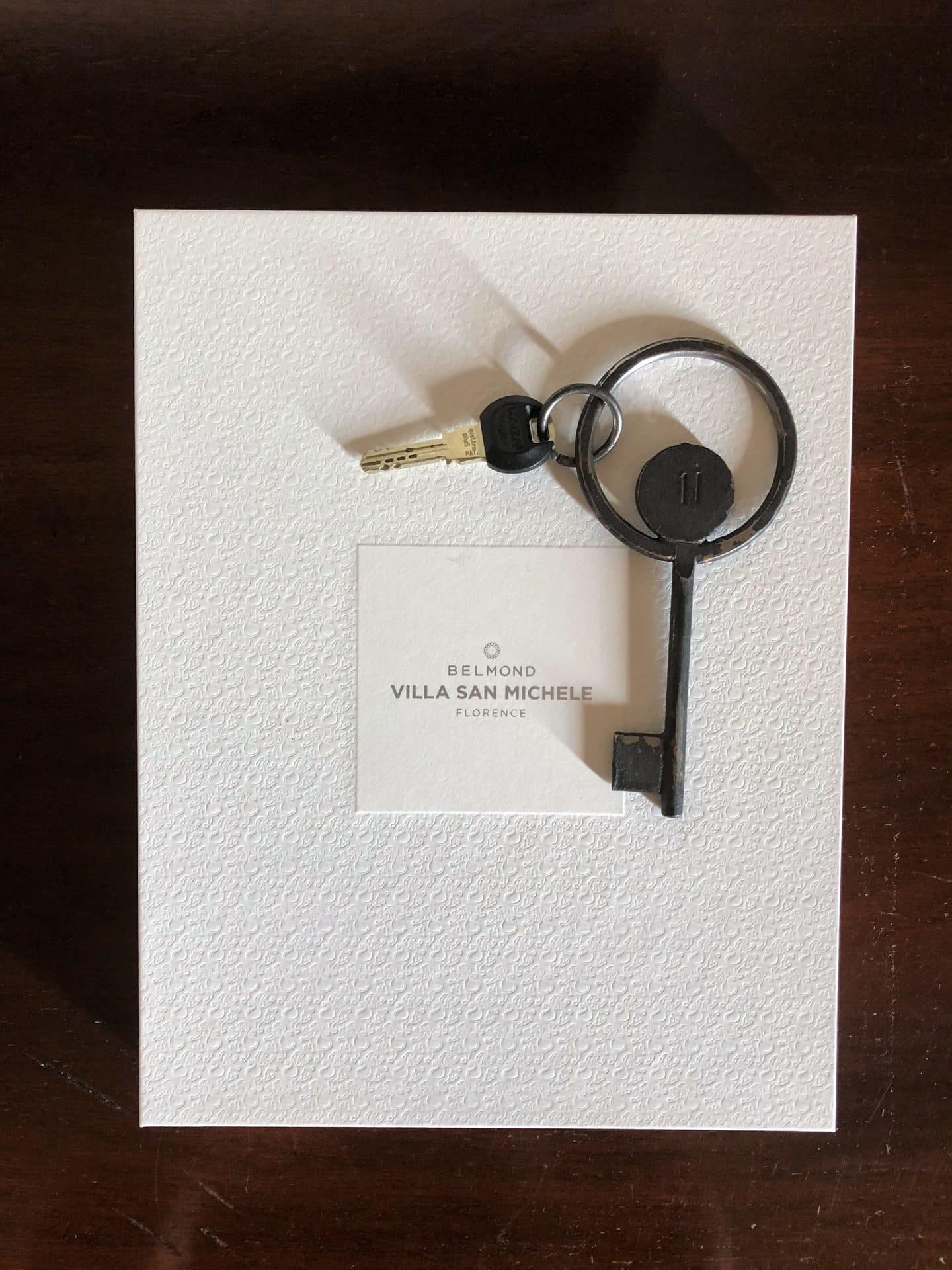 The door key to the suoerior room in the cloister against a Belmond Villa San Michele white card.