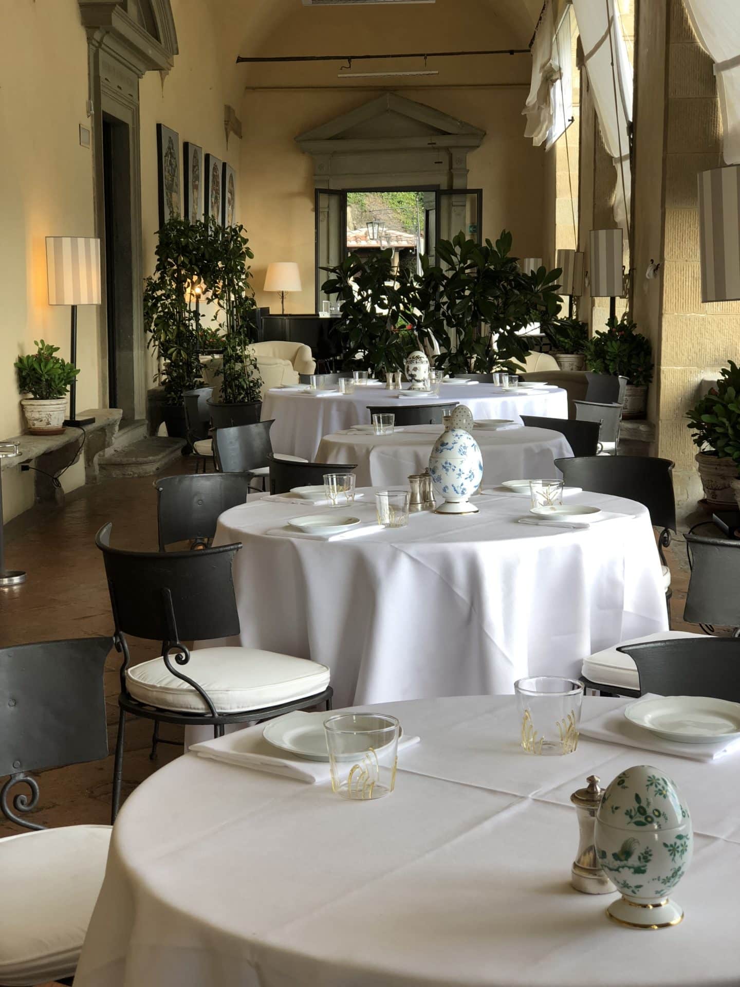 La Loggia restaurant with circular tables in a row all with white table cloths and crockery on table. 