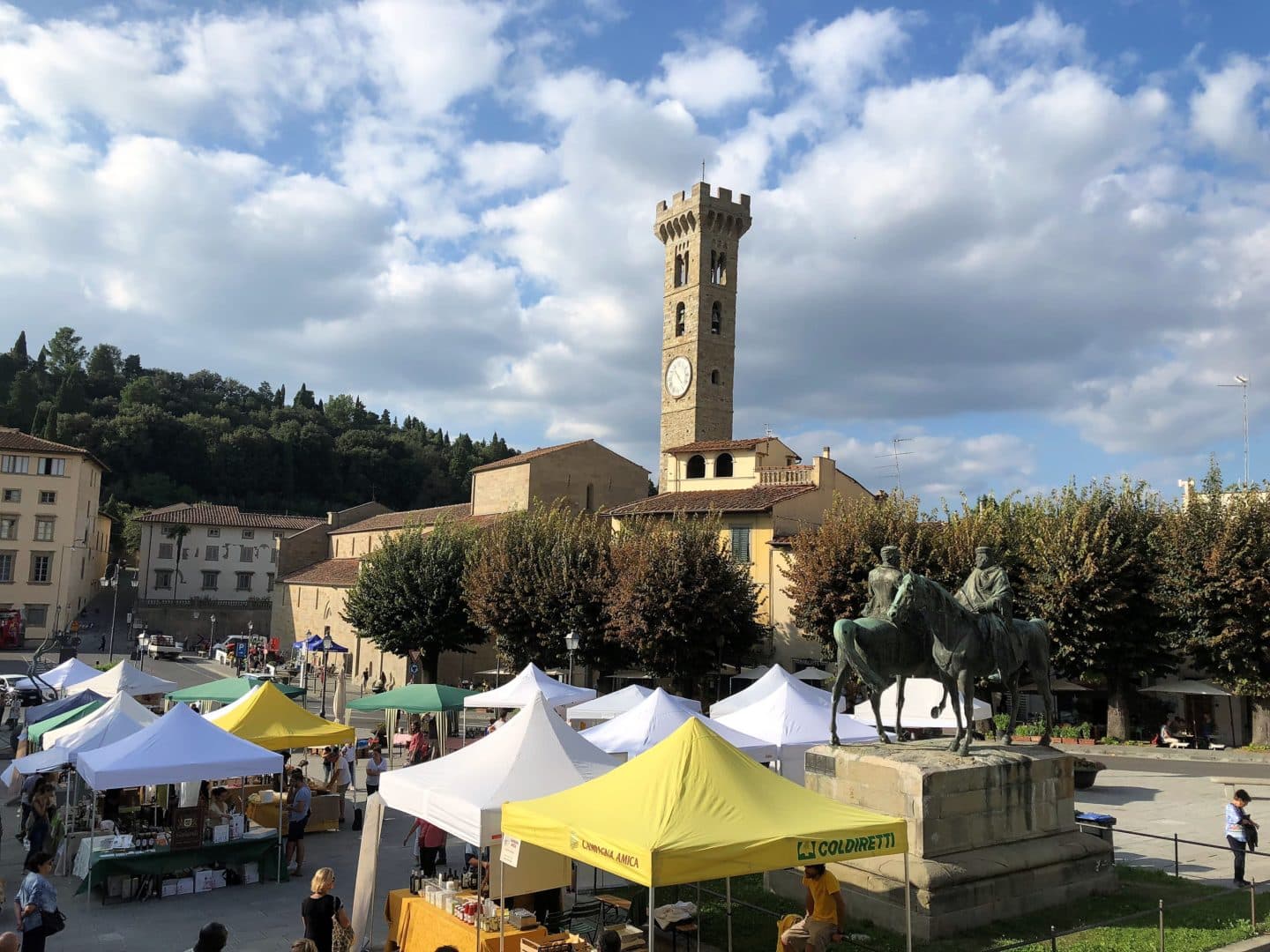 The market stalls in the town of Fiesole with the church tower in the background.
