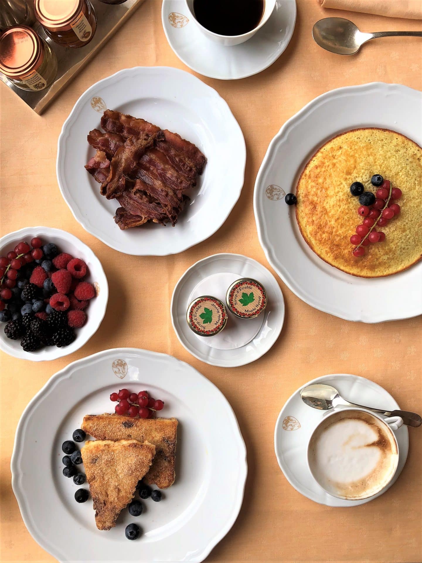 Belmond Villa San Michele: Flatlay photo of breakfast items including French toast, berries, yoghurts, pancakes, cappuccinos and black coffee.
