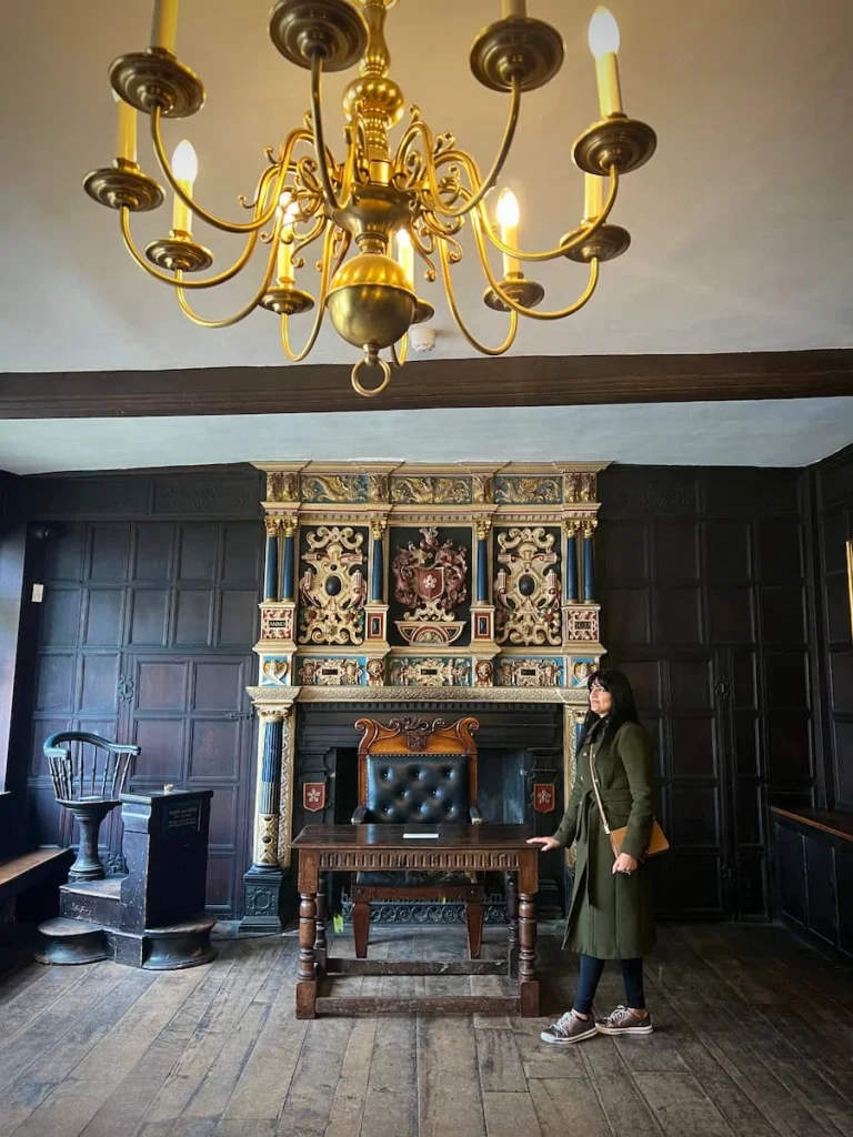 Bejal standing in downstairs room of Guildhall, Leicester with table and a black chair behind her