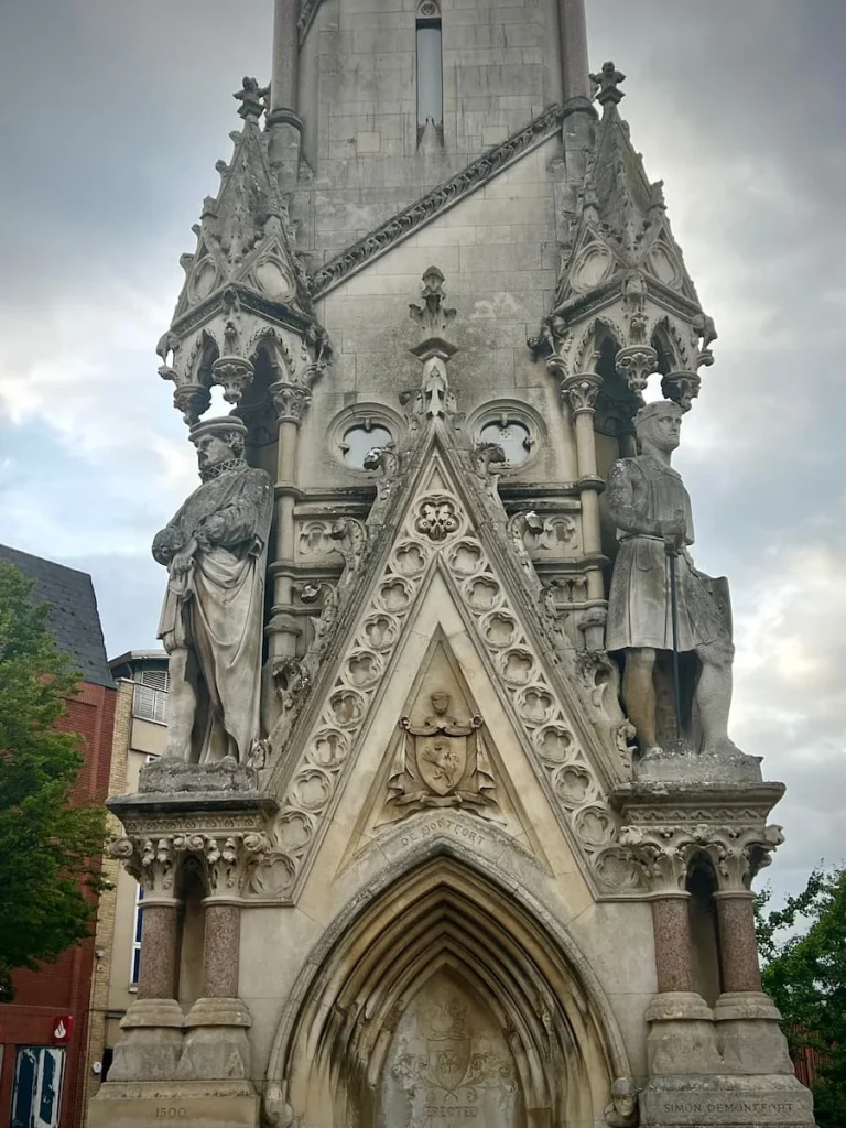 Close up of the grey stone work of Leicester Clock Tower featuring important historical people from the city of Leicester who have helped the city both socially and financially