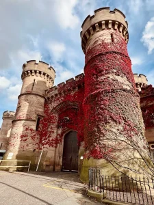 Leicester prison in autumn time with the red and maroon leaves on the facade. The turrets are covered in leaves