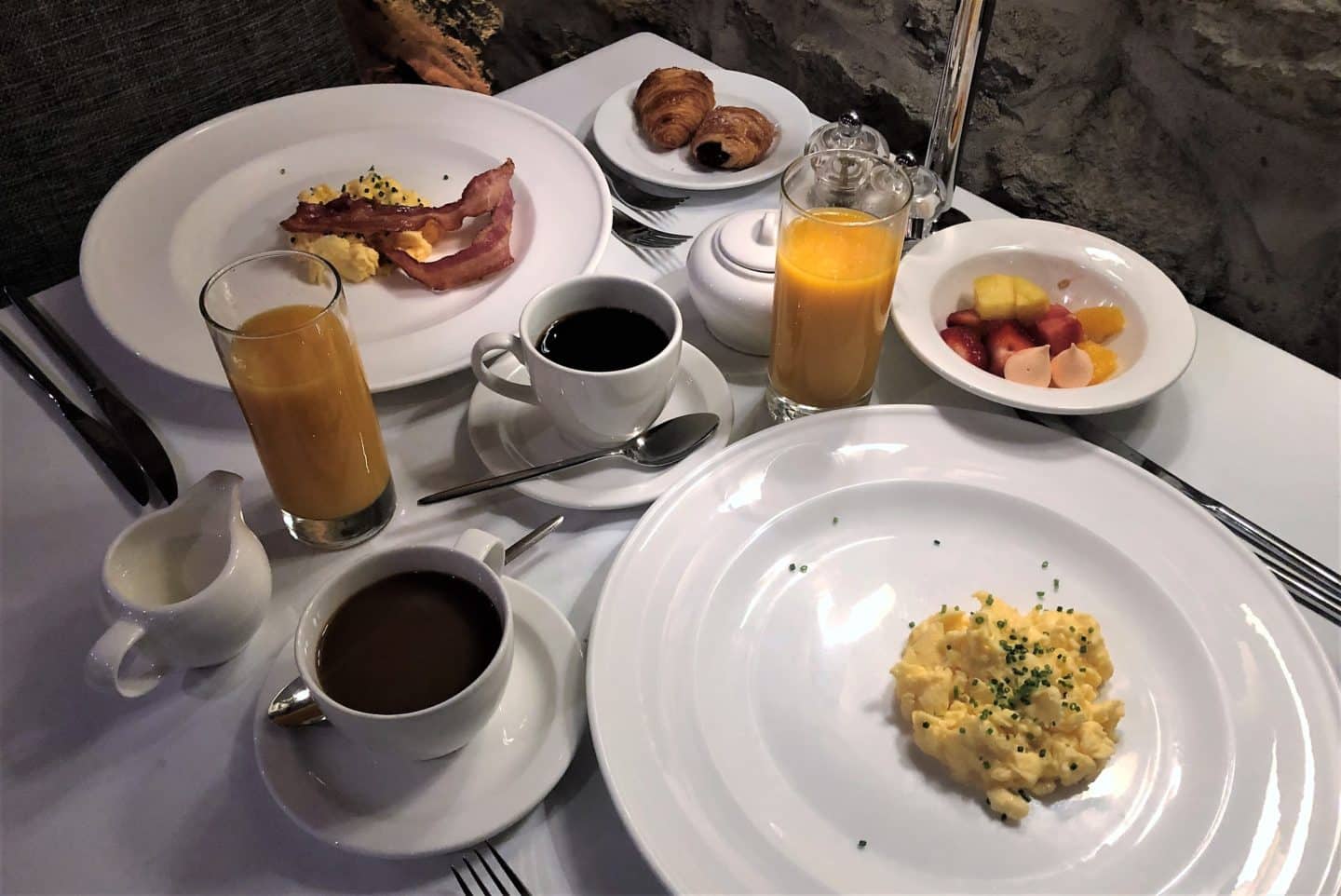 The Schlossle Hotel Tallinn: A side view image of of breakfast with orange juice, pain au chocolat, black coffee and scrambled eggs at the Stenhus Restaurant 