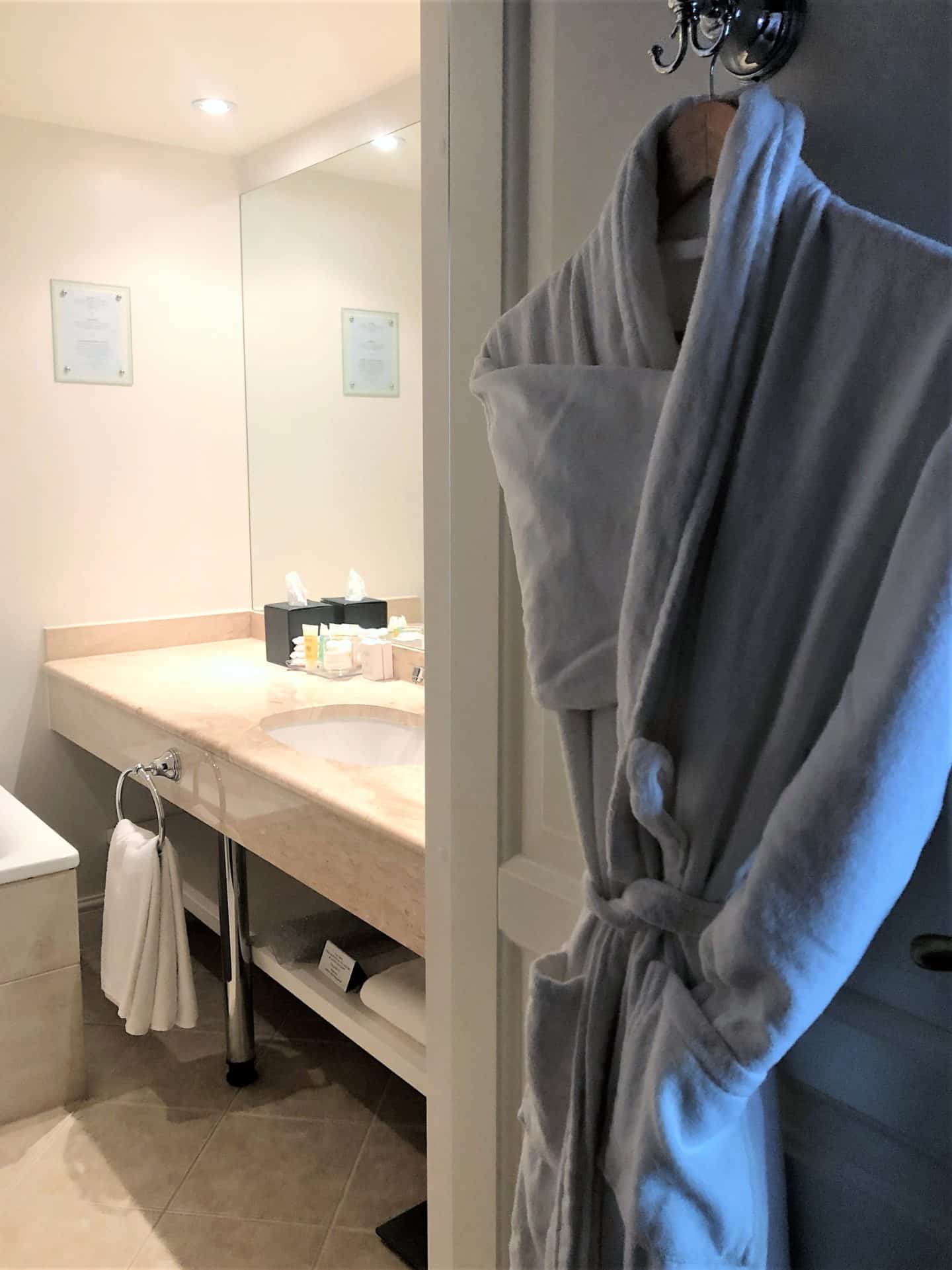 The Schlossle Hotel Tallinn: A fluffy white robe hanging on the bathroom door in the deluxe garden suite room