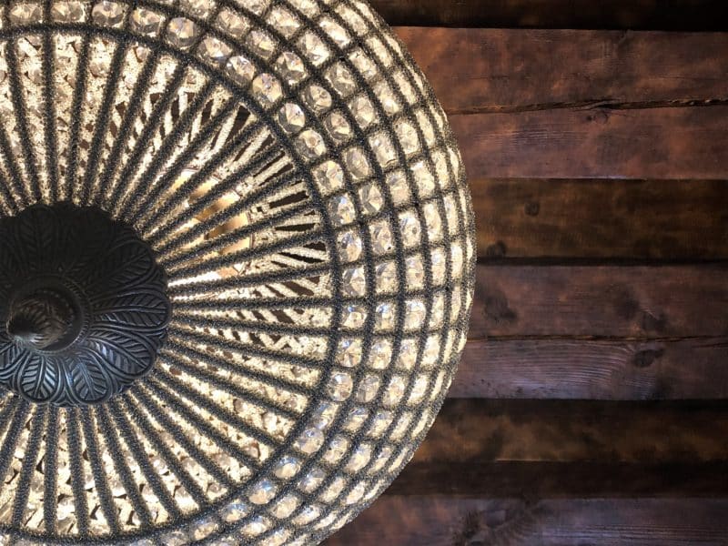 The Schlossle Hotel Tallinn: The moroccan themed light fitting shot against the brown beams of the ceiling in the deluxe garden suite