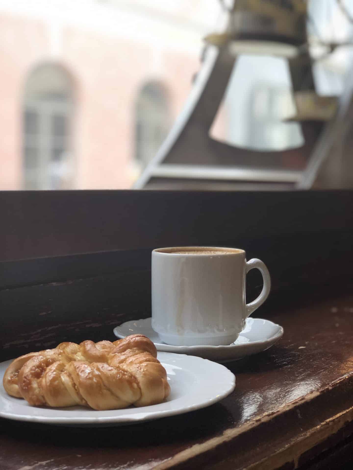 Side views of coffees and Estonian pastries at Maiasmokk cafe in Old Town Tallinn. They are placed on a mid-brown coloured table. 