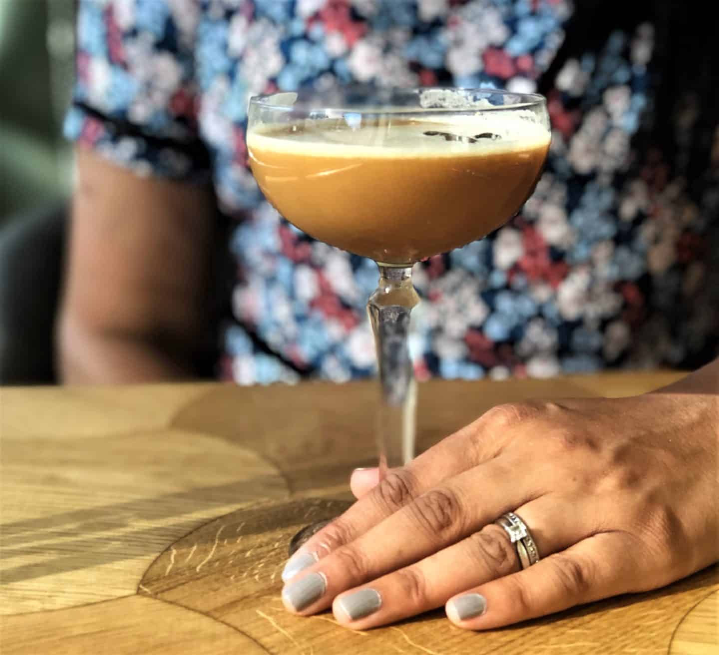 Vegetarian food in Tallinn, interiors of Pegasus restaurant with Bejal holding an Espresso Martini