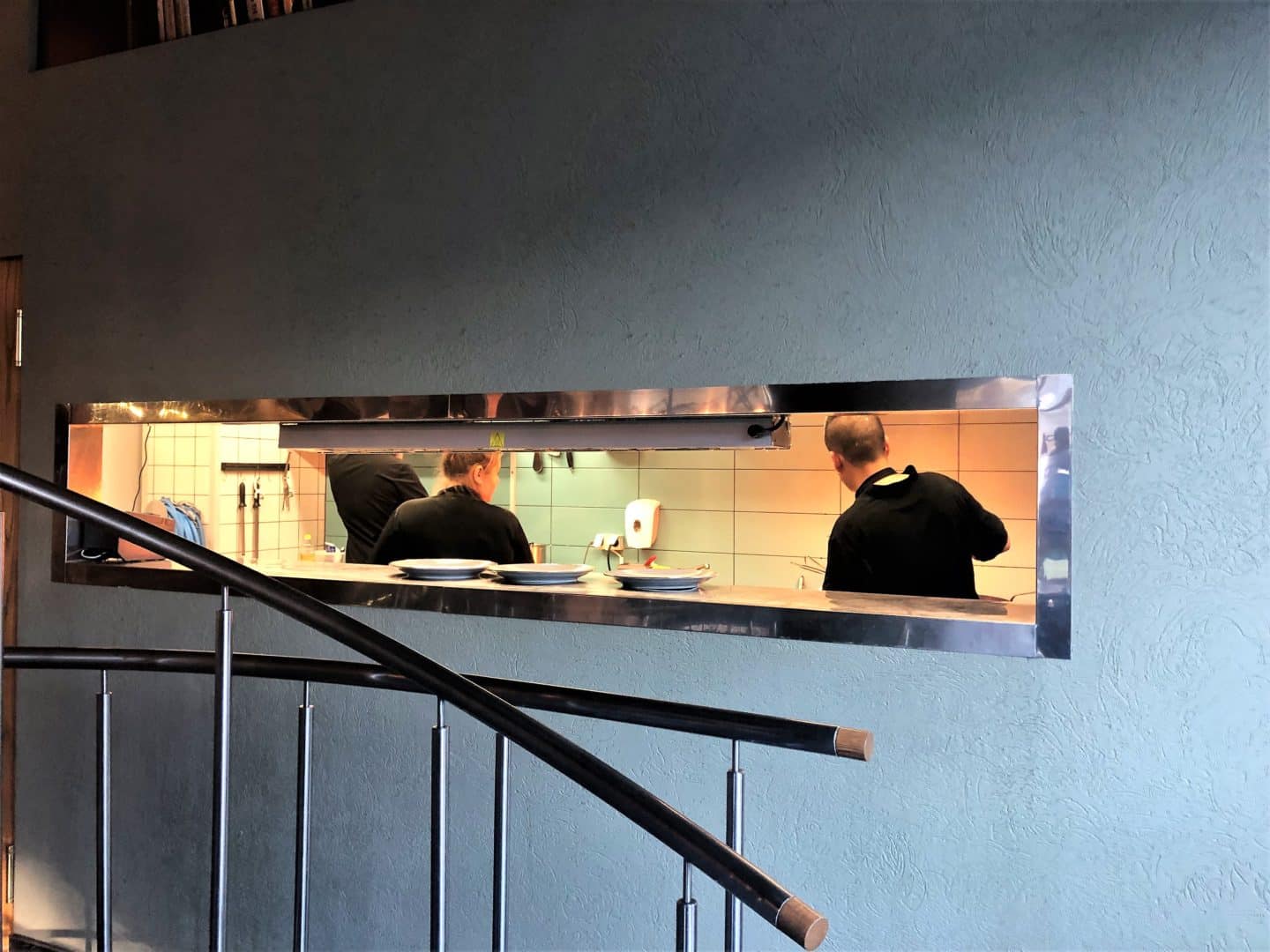 Vegetarian food in Tallinn, interiors of Pegasus restaurant with open kitchen with chefs in the background cooking