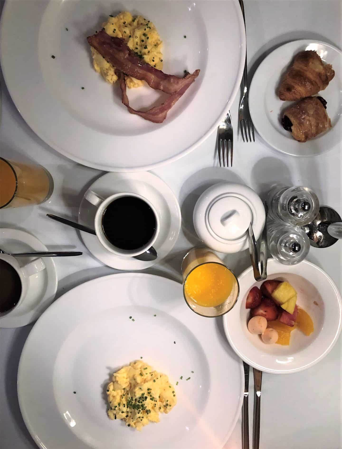 The Schlossle Hotel Tallinn: A top lay image of of breakfast with orange juice, pain au chocolat, black coffee and scrambled eggs at the Stenhus Restaurant 
