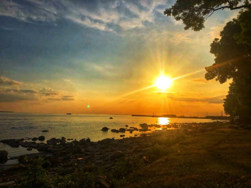 The sunset over Tallinn Bay just outside Noa Restaurant with the water and pebbles helping to create a perfect orange, yellow silhouette.