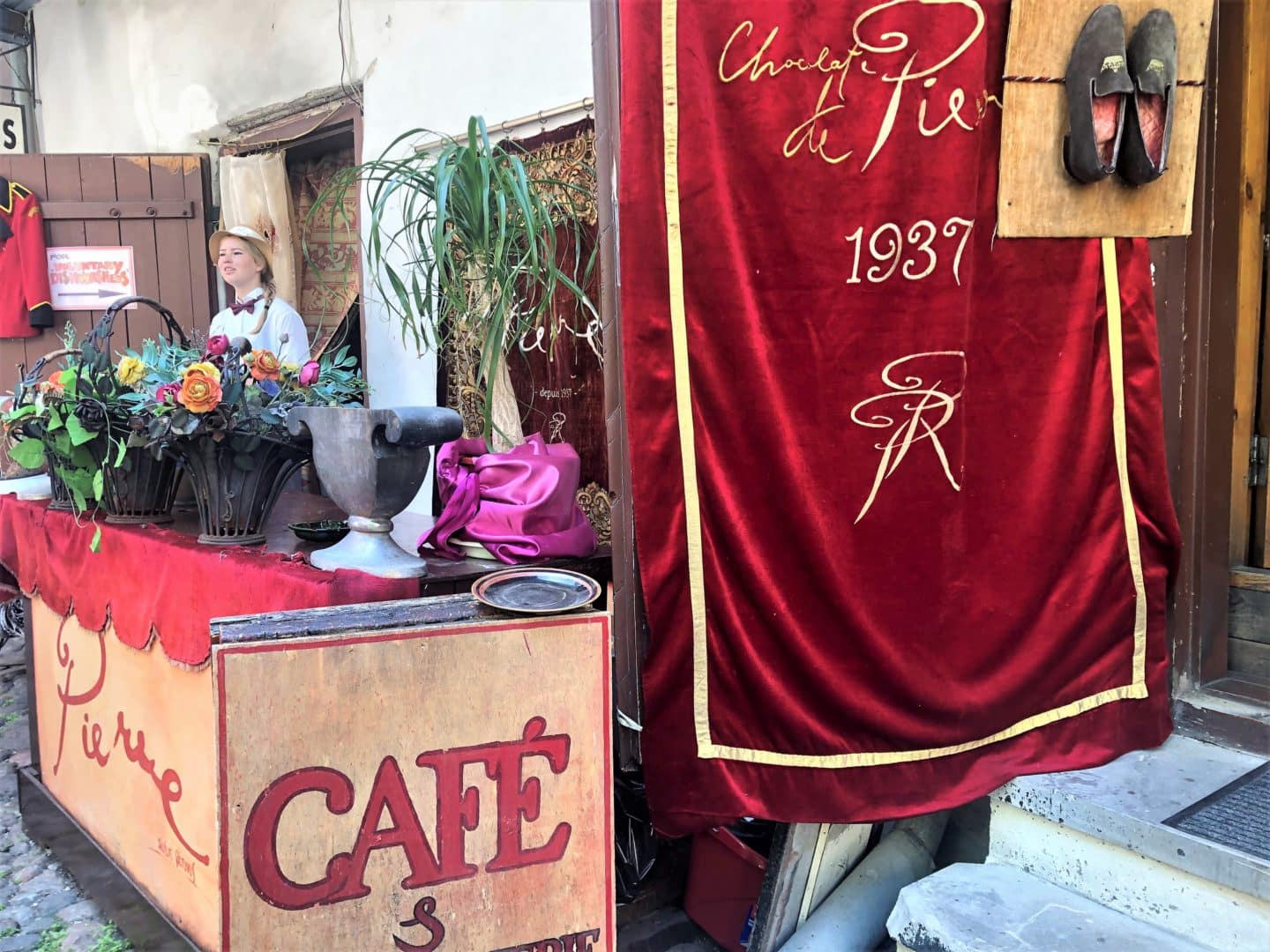 The entrance to Pierre Chocolaterie, Tallinn with its quirky red velvet curtain and staff ember standing outside