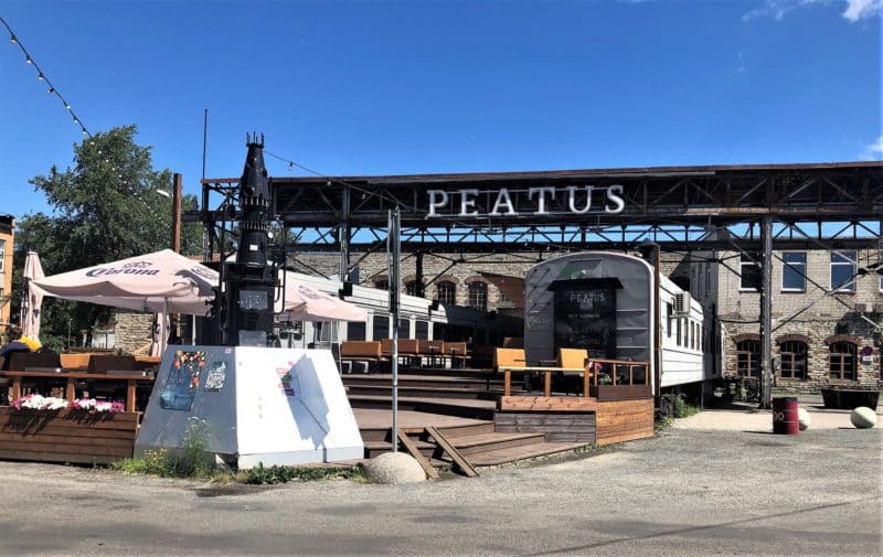 Peatus disused train carriage in Kalamaji in Tallinn. Blue skies and casual tables and seating outside