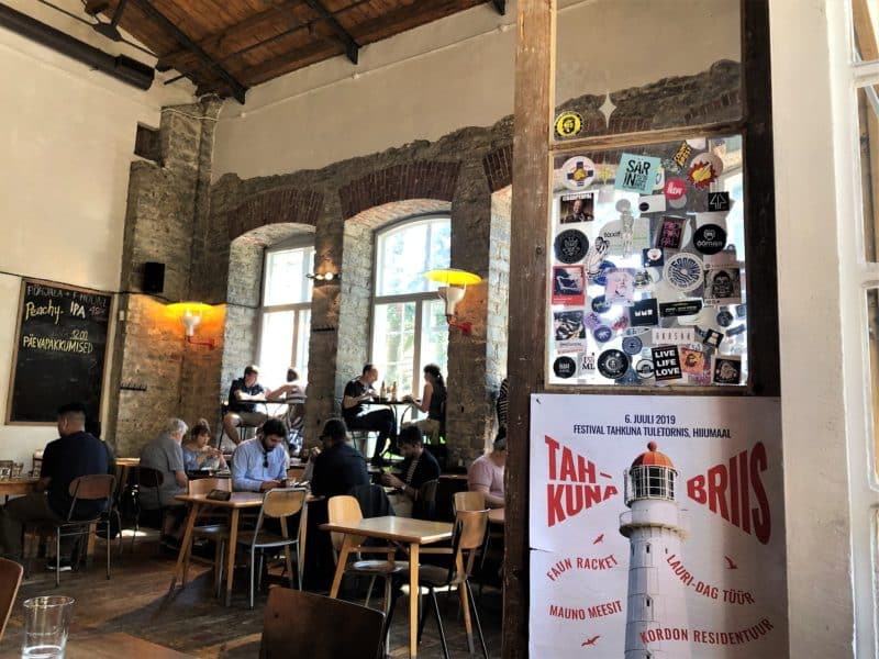 The interiors of F-Hoone with high ceilings and open brick work with diners eating and drinking, Tallinn