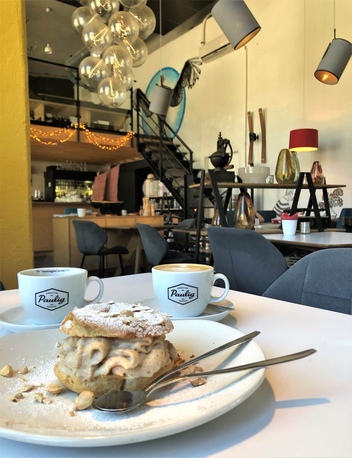 The interiors at French Bistro, Tallinn with a Paris breast filled with cream and coffees in small espresso cups on a white table