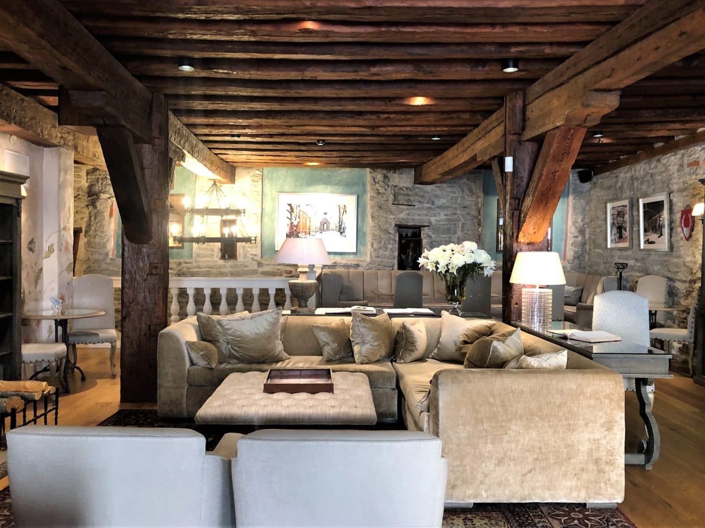 The Schlossle Hotel Tallinn: The lounge and lobby with beamed brown ceilings, a huge comfy corner sofa and stoned walls.