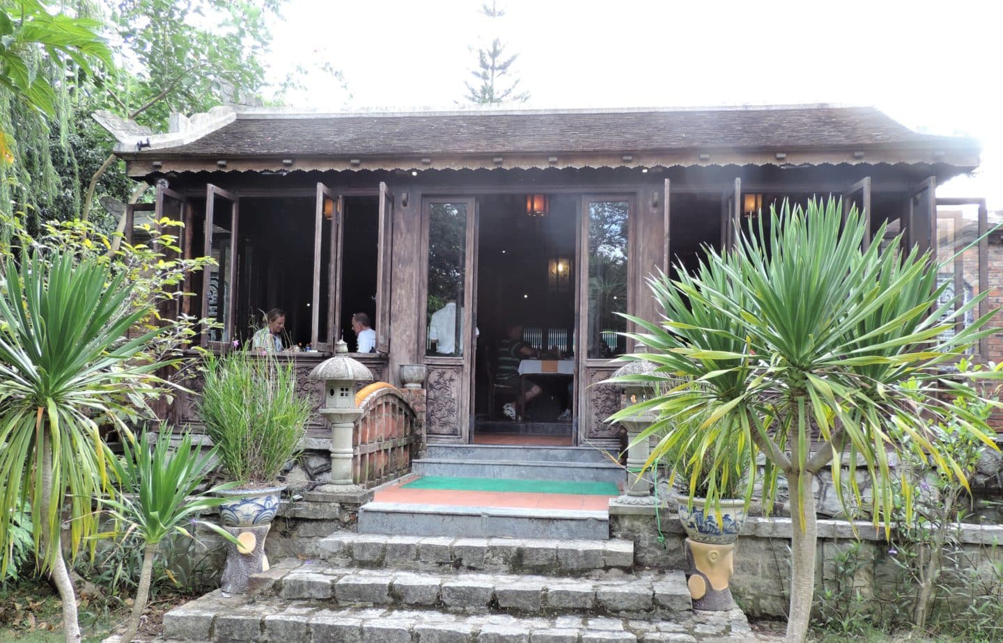 Citadel restaurant in Hue called Thao Garden. The restaurant is surrounded by plants and bushes.