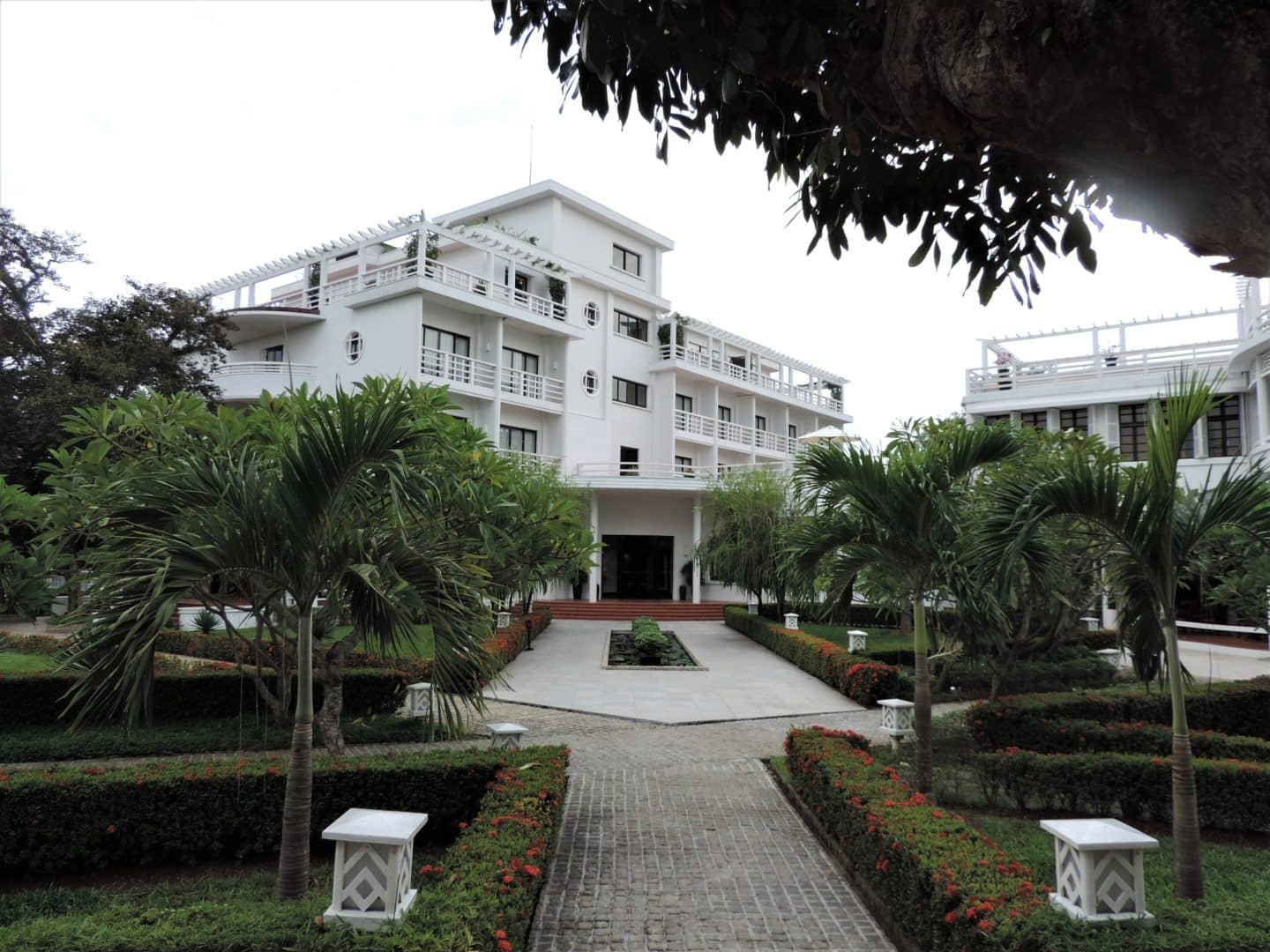 Azarai La Residence Hotel, Hue white exterior framed with green foliage and trees
