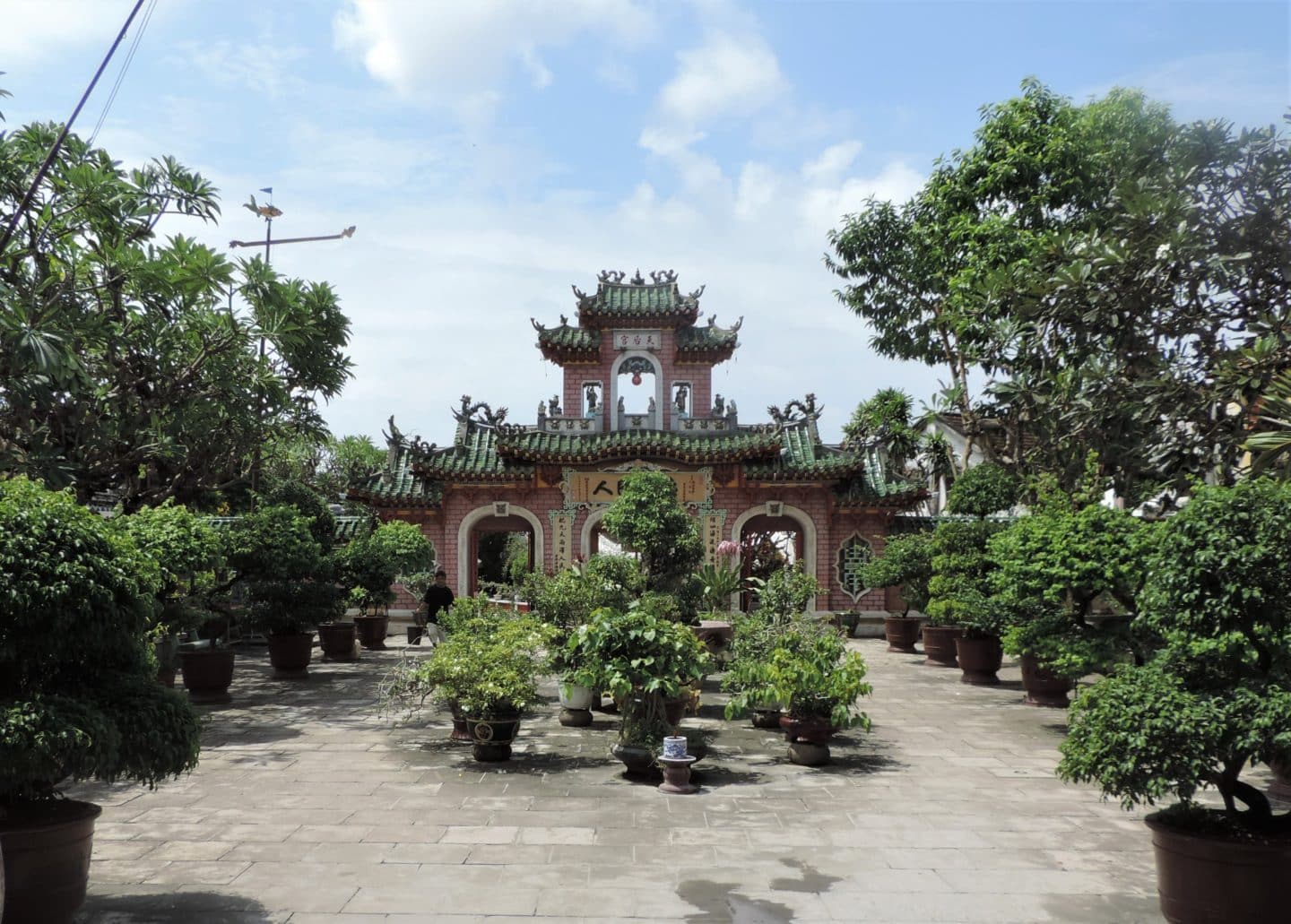 Cantonese Pagodas exterior with foliage and plants surrounding the structure in Hoi An
