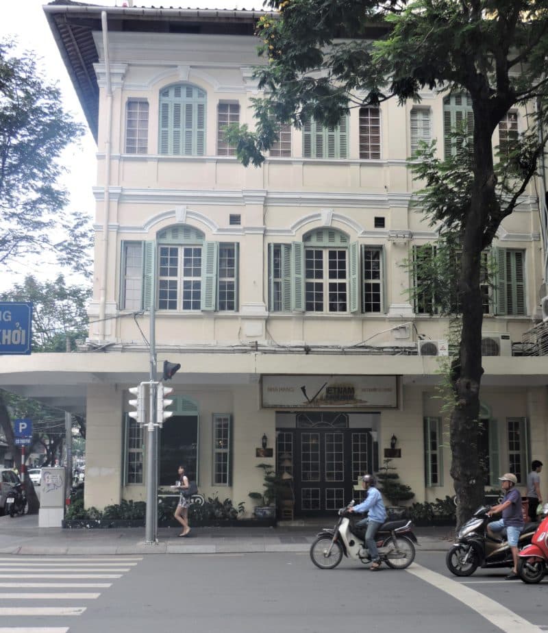 Vietnam in 14 days: Vietnam House Restaurant exterior with motorcycles  queuing up outside and a lady walking by 