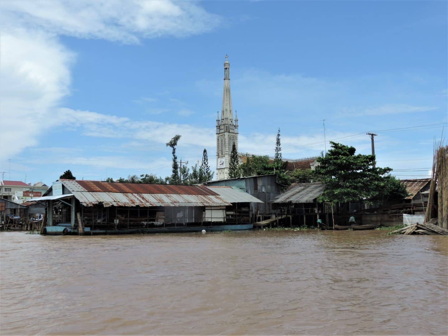 Vietnam in 14 Days: Mekong Delta cruise with the spire of the cathedral in the background.