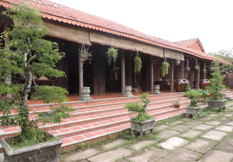 Vietnam in 14 Days: Local House along the Mekong River for dinner, which has plant hanging baskets on the exterior