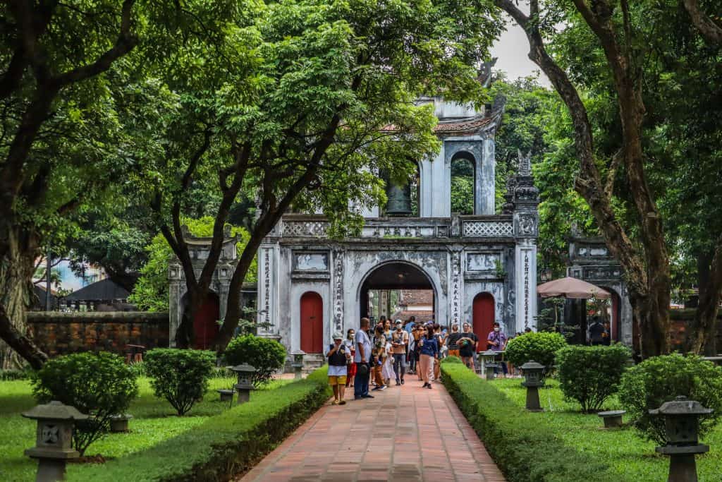 Vietnam in 14 days: The temple of Literature, Hanoi with pruned gardens and topiary on either side with crowds walking down the central aisle