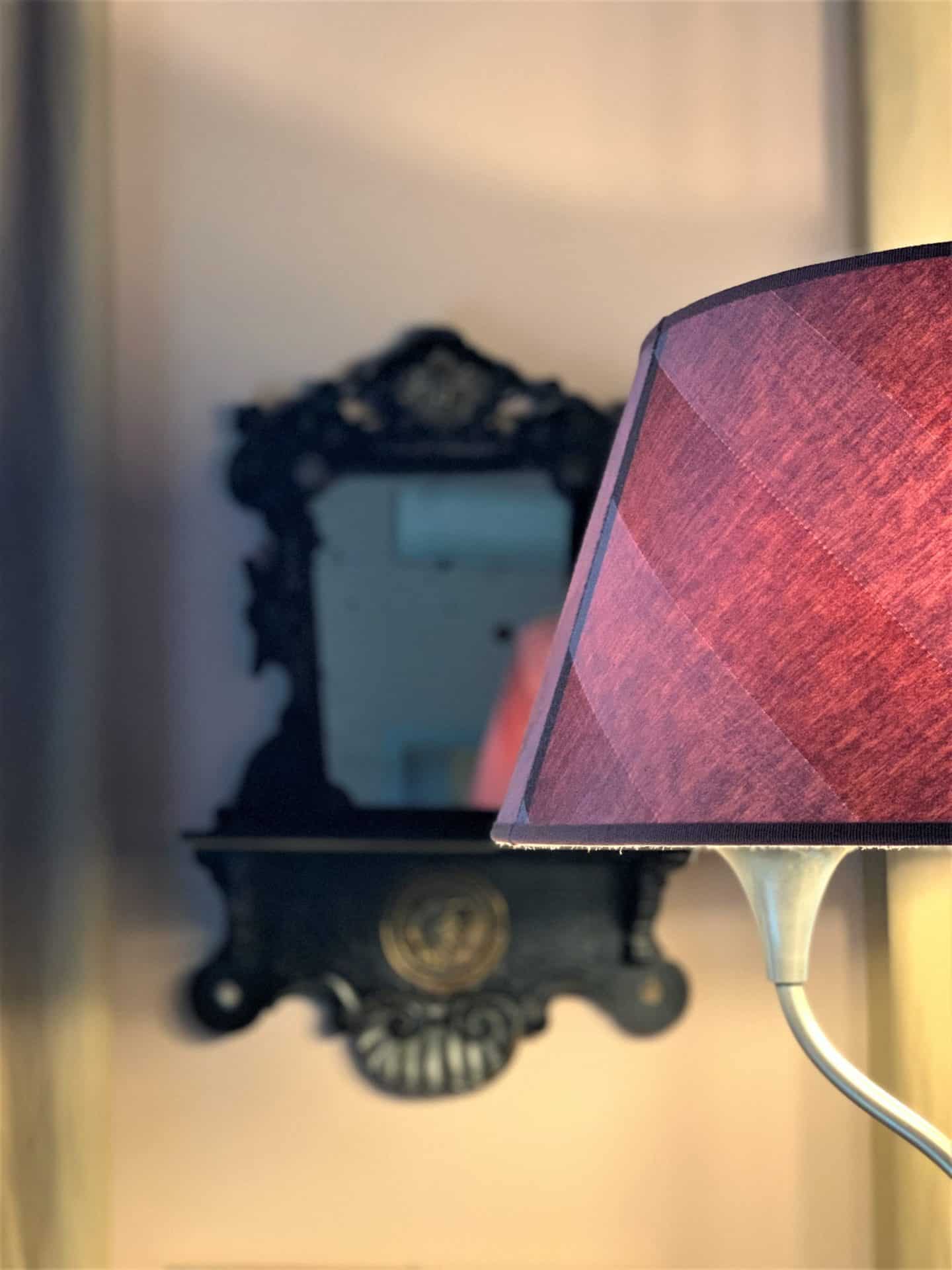 Dark pink light with ornate mirror in background