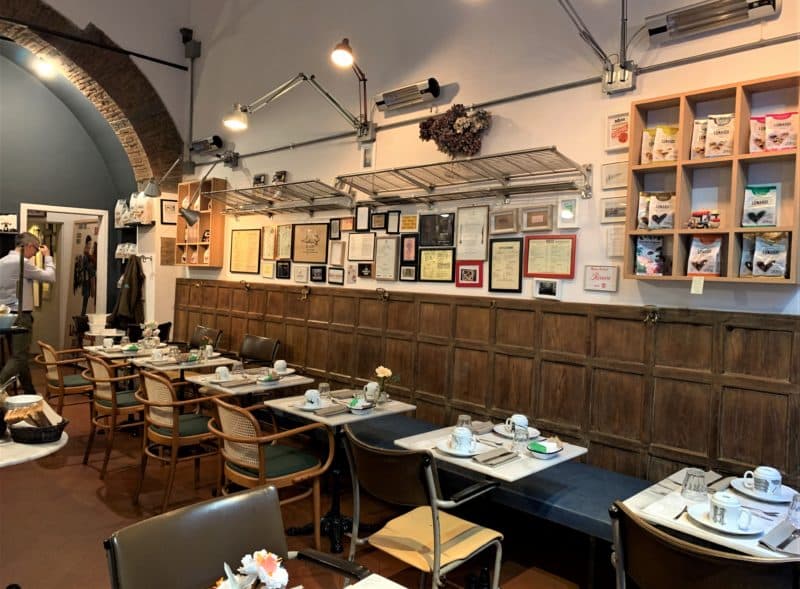 The interiors of the Sottarno Commestibili cafe, with wood panelling adn tables for 2.. the tables are set with crockery and cutlery