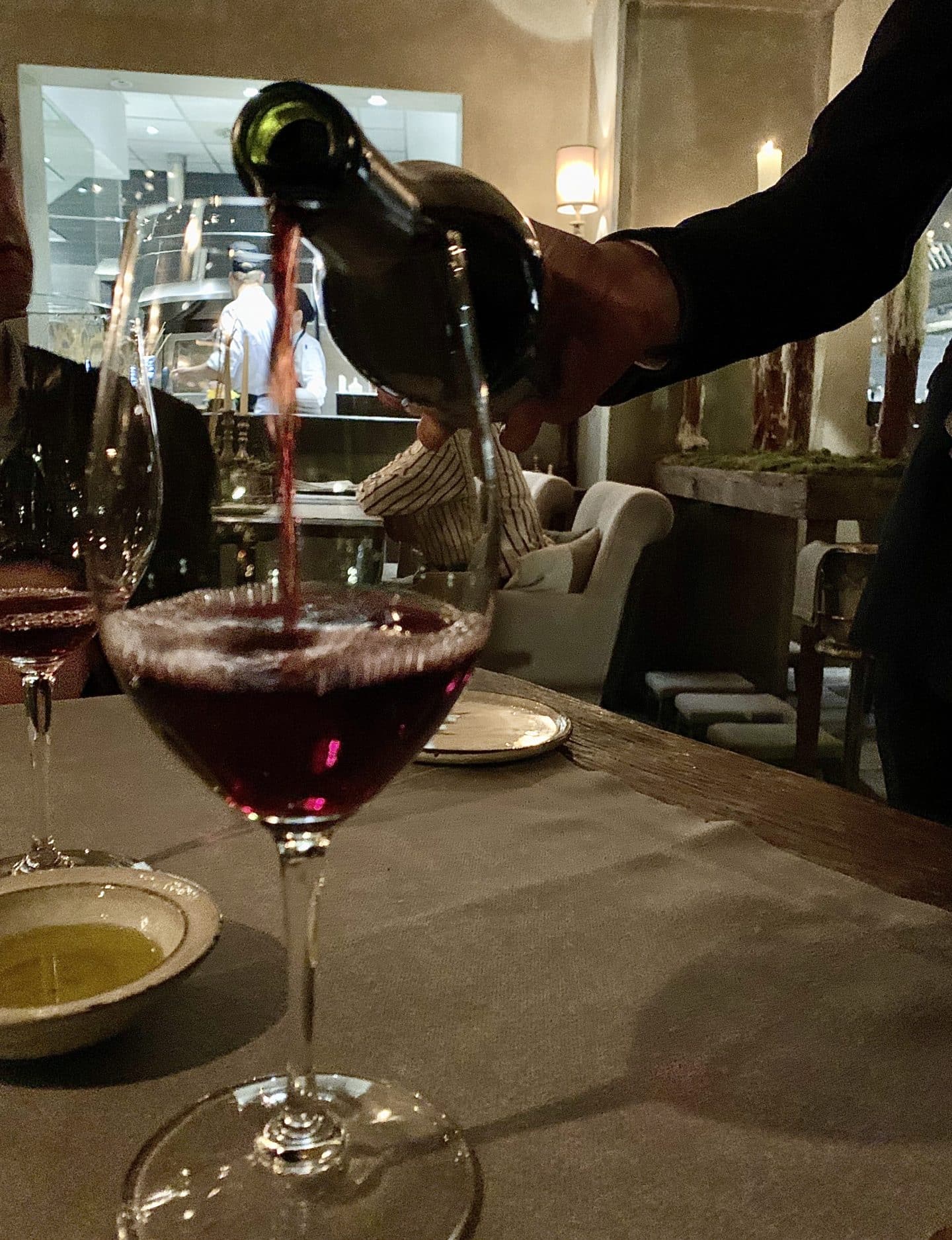 Sommelier pouring a glass of red wine at La Bottega del Buon Caffe, Florence