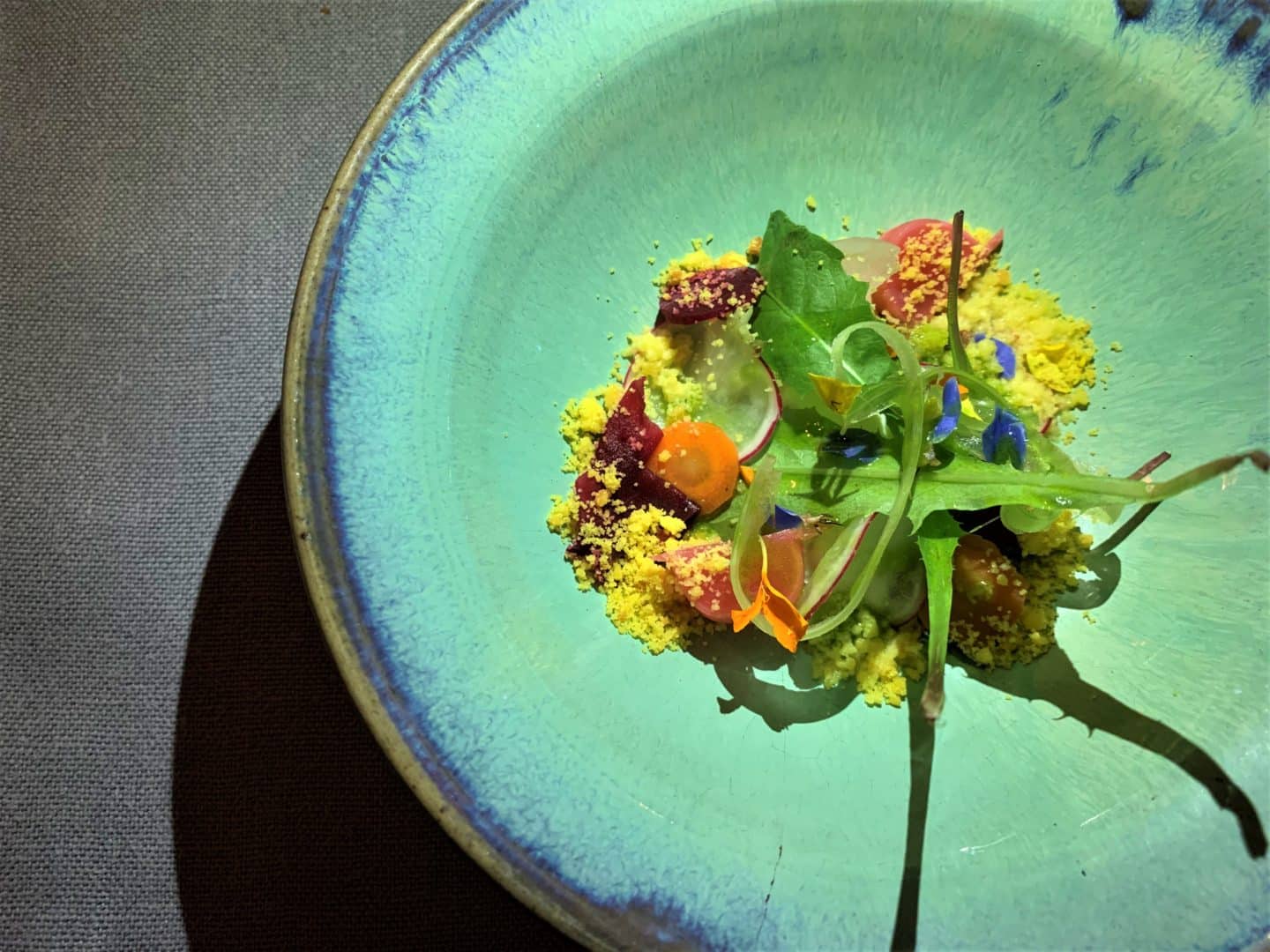 A turquoise plate with multi-coloured leaves in the middle, at La Bottega del Buon Caffee