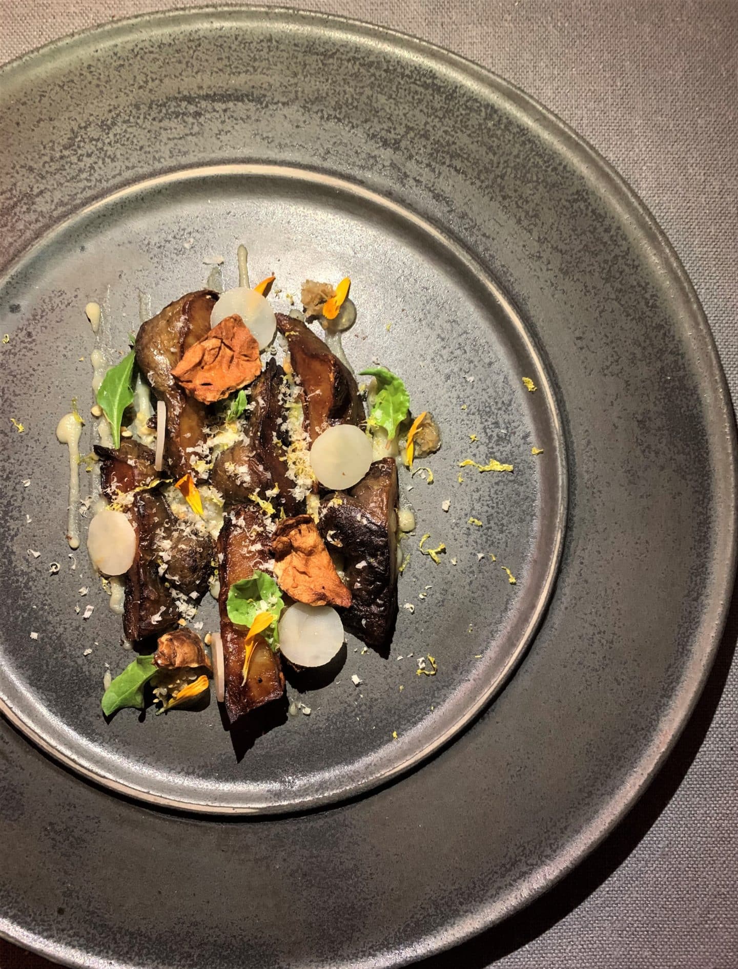 A dark brown plate with mushrooms and in autumnal tones at La Bottega del Buon Caffee.